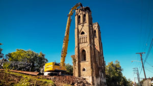 High reach excavator tearing down church